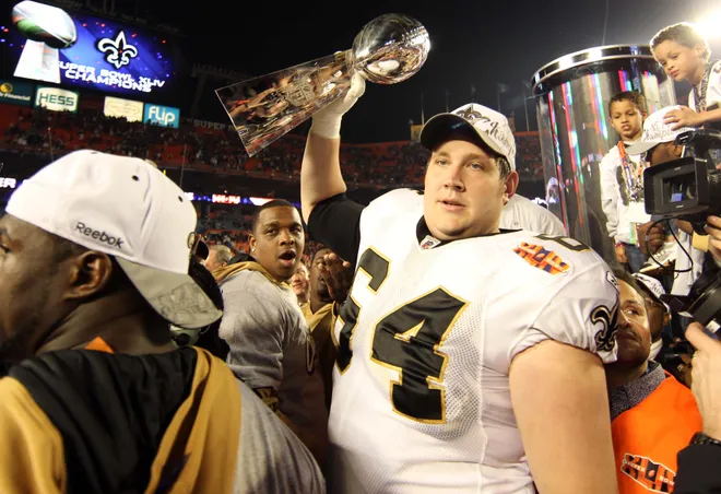 Feb 7, 2010; Miami, FL, USA; New Orleans Saints offensive tackle Zach Strief (64) hoists the Lombardi Trophy and celebrates after defeating the Indianapolis Colts 31-17 in Super Bowl XLIV at Sun Life Stadium. Mandatory Credit: Matthew Emmons-USA TODAY Sports