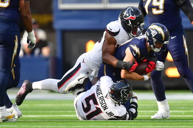 Dec 27, 2025; Inglewood, California, USA; Los Angeles Chargers quarterback Justin Herbert (10) is sacked by Houston Texans defensive end Danielle Hunter (55) and defensive end Will Anderson Jr. (51) during the first half at SoFi Stadium. Mandatory Credit: Gary A. Vasquez-Imagn Images