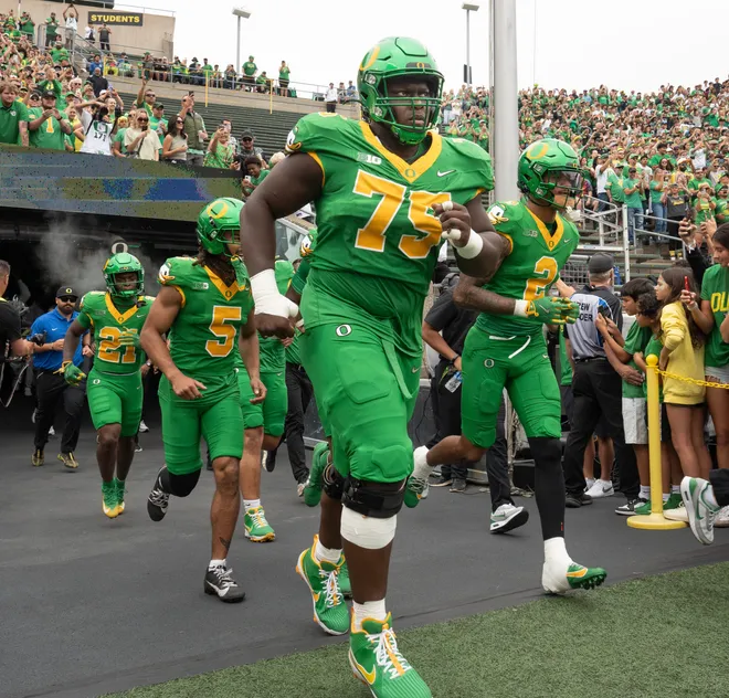 Oregon’s Emmanuel Pregnon, center, takes the field before the game against Oklahoma State at Autzen.