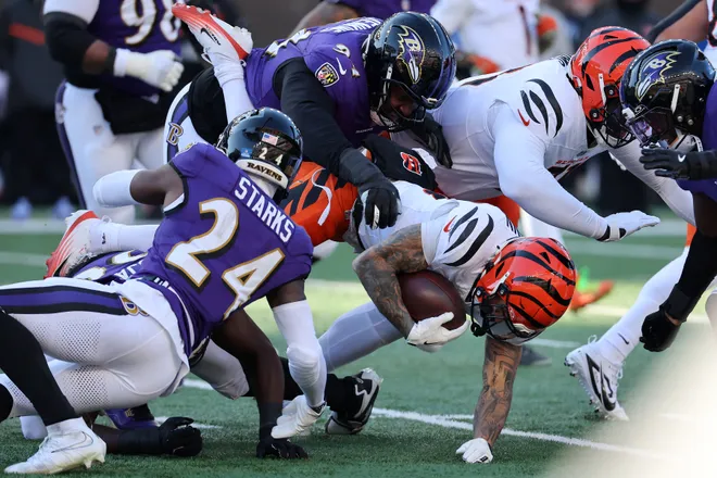 Dec 14, 2025; Cincinnati, Ohio, USA; Cincinnati Bengals running back Chase Brown (30) runs the ball as Baltimore Ravens safety Malaki Starks (24) and defensive tackle John Jenkins (94) make the tackle during the second quarter at Paycor Stadium. Mandatory Credit: Joseph Maiorana-Imagn Images