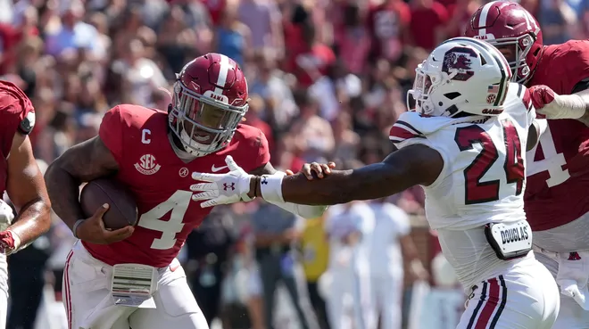 Oct 12, 2024; Tuscaloosa, Alabama, USA; Alabama Crimson Tide quarterback Jalen Milroe (4) tries to avoid a tackle attempt by South Carolina Gamecocks defensive back Jalon Kilgore (24) at Bryant-Denny Stadium. Alabama defeated South Carolina 27-25. Mandatory Credit: Gary Cosby Jr.-Imagn Images
