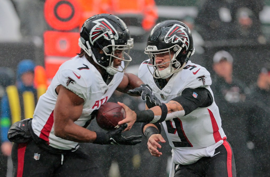 Atlanta Falcons #9 Desmond Ridder hands the ball to #7 Bijan Robinson.
