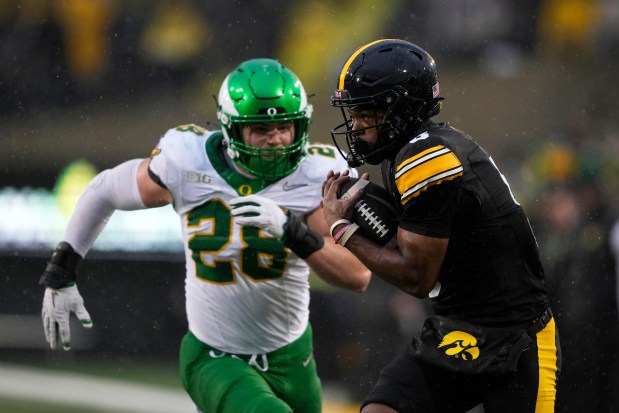 Iowa wide receiver Jacob Gill (5) catches a pass in front of Oregon linebacker Bryce Boettcher (28) during the first half of a game Saturday, Nov. 8, 2025, in Iowa City, Iowa. (AP Photo/Charlie Neibergall)