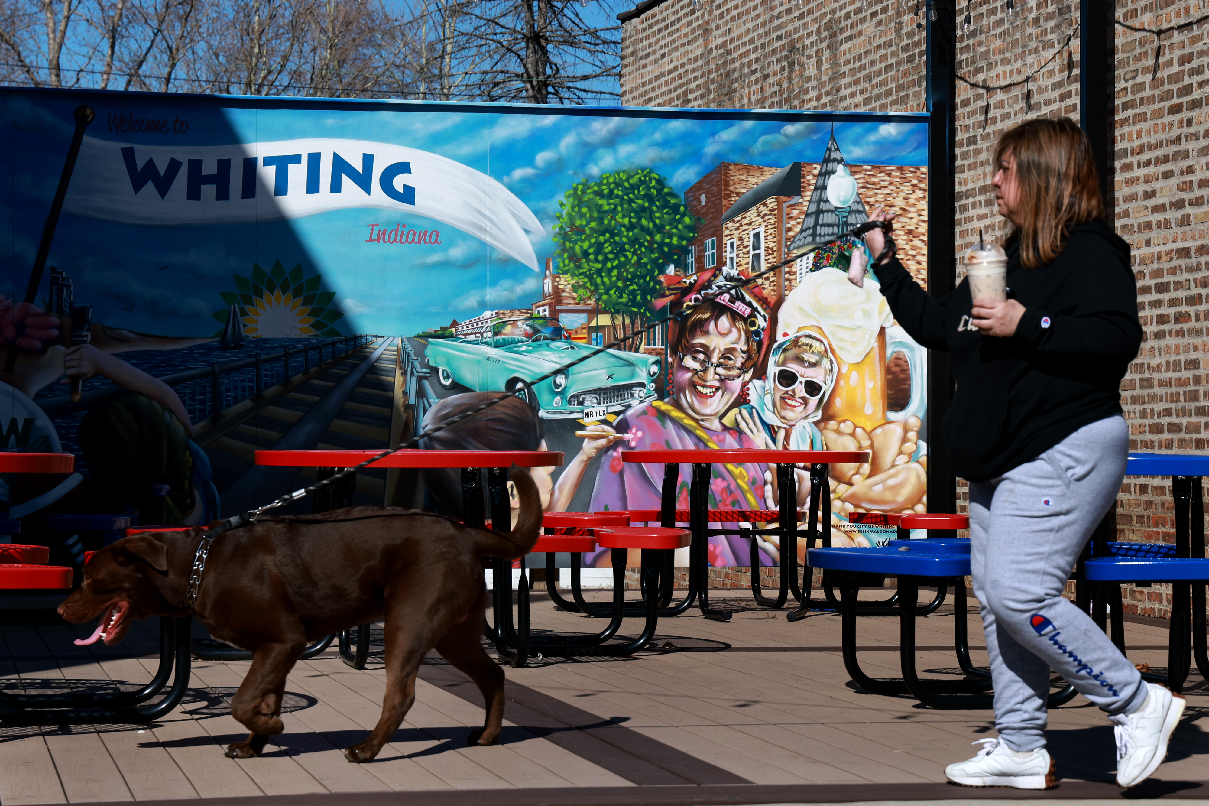 A woman walks her dog in Whiting, Indiana, along 119th...