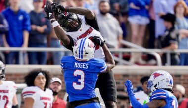 Louisville wide receiver Chris Bell (0) catches a pass as SMU safety Ahmaad Moses (3) defends in the first half of an NCAA college football game Saturday, Nov. 22, 2025, in Dallas. (AP Photo/Tony Gutierrez)