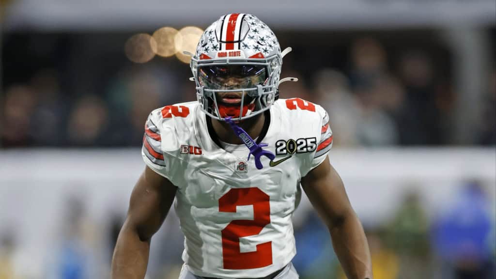 Caleb Downs in Ohio State’s white No. 2 uniform stands ready before the snap during a college football game.