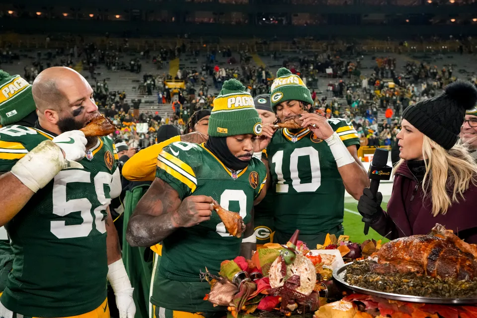 Quarterback Jordan Love #10 of the Green Bay Packers, linebacker Isaiah McDuffie #58, and running back Josh Jacobs #8 enjoy Thanksgiving turkey with NBC Sports reporter Melissa Stark after an NFL football game against the Miami Dolphins, at Lambeau Field