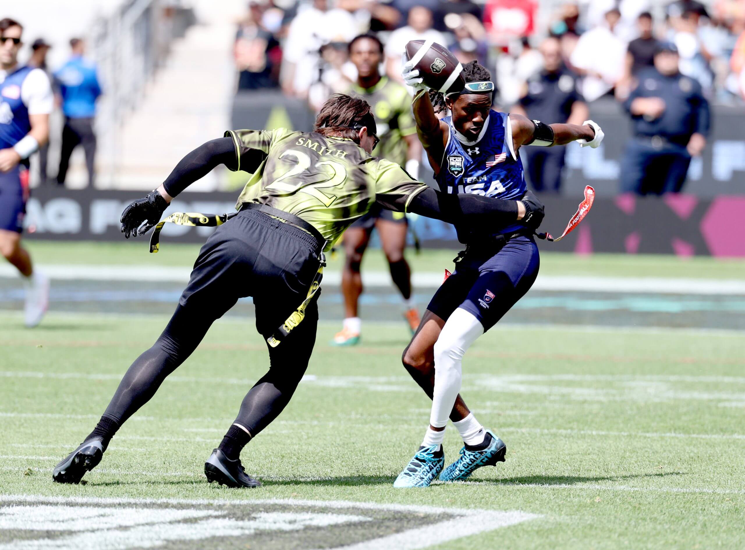 A flag football player grapples for the flag of another player who has the ball. 