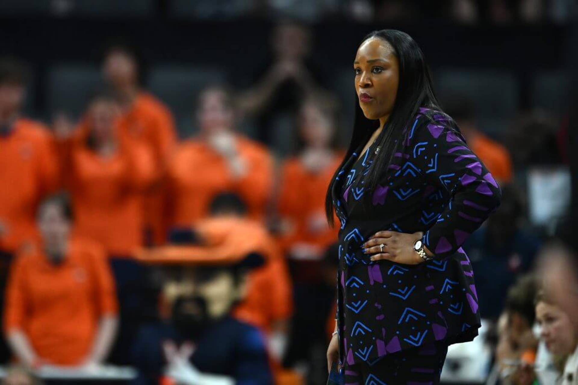 Virginia coach Amaka Agugua-Hamilton rests her left hand on her hip as she looks on during a game against TCU.