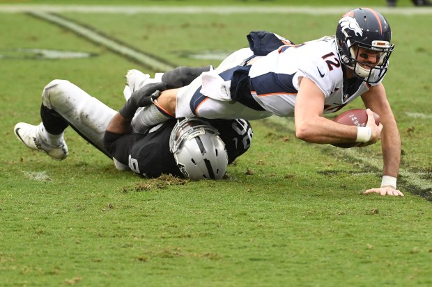 Paxton Lynch of the Denver Broncos is sacked by Denico Autry of the Oakland Raiders during their NFL game at Oakland-Alameda County Coliseum on November 26, 2017 in Oakland, California. (Photo by Robert Reiners/Getty Images)