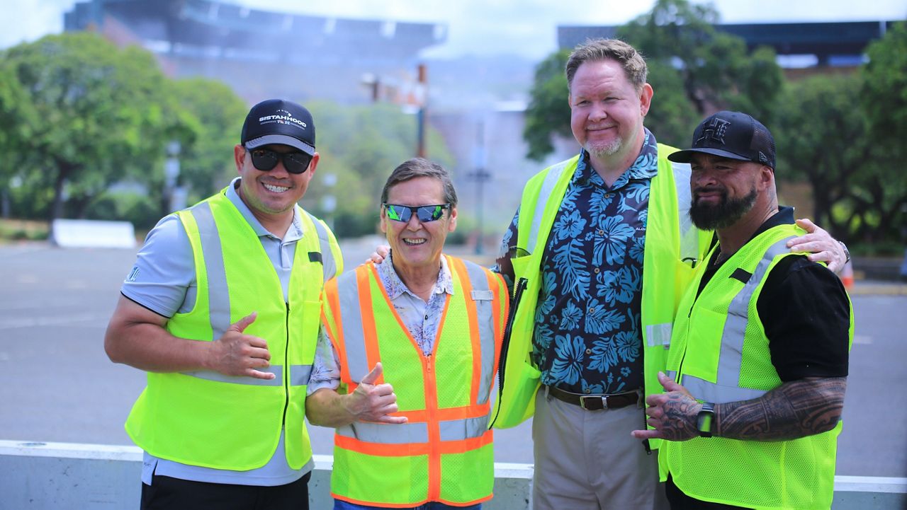 From left, Hawaii football coach Timmy Chang, Stanford Carr Development President Stanford Carr, interim stadium manager Michael Yadao and UH football associate head coach Chris Brown posed moments after an upper section of Aloha Stadium, in background, was torn down with a "rollover" maneuver on Thursday.