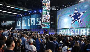 Draft day event with fans inside a stadium, showcasing large digital screens, team banners, and a vibrant atmosphere during the NFL Draft at the Cowboys' Selection Square.