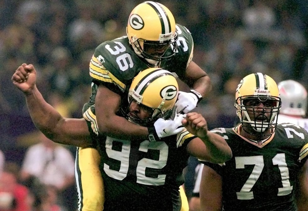 Green Bay Packers defensive end Reggie White (92) is congratulated by LeRoy Butler (36) after...