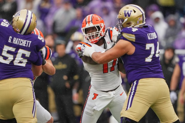 Illinois defensive end Gabe Jacas is blocked in action against Washington offensive lineman Drew Azzopardi during an NCAA football game, Saturday, Oct. 25, 2025, in Seattle. (AP Photo/Lindsey Wasson)