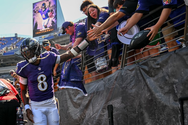 Baltimore Ravens quarterback Lamar Jackson (8) high-fives fans as he enters the game ahead of the Ravens game against the Cleveland Browns at M&T Bank Stadium.