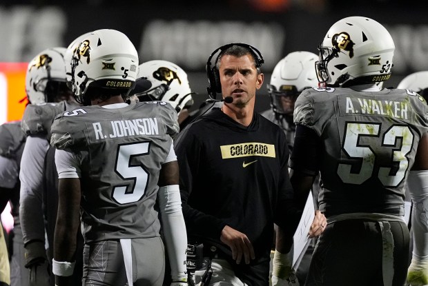 Colorado defensive coordinator Robert Livingston, center, confers with safety RJ Johnson, left, and defensive end Arden Walker in the second half of a game against Cincinnati Saturday, Oct. 26, 2024, in Boulder, Colo. AP Photo/David Zalubowski)