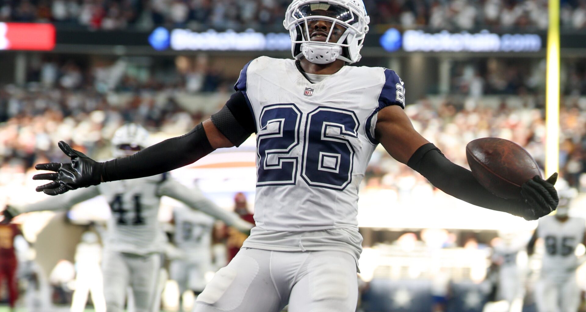 Oct 19, 2025; Arlington, Texas, USA; Dallas Cowboys cornerback Daron Bland (26) carries the ball after an interception for a touchdown against the Washington Commanders during the third quarter of the game at AT&T Stadium.