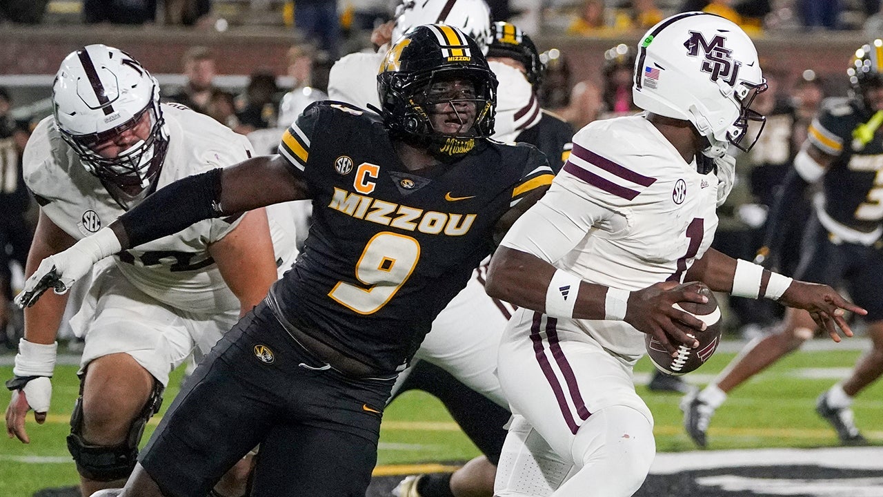 Nov 15, 2025; Columbia, Missouri, USA; Mississippi State Bulldogs quarterback Kamario Taylor (1) runs the ball as Missouri Tigers defensive end Zion Young (9) attempts the sack during the second half of the game at Faurot Field at Memorial Stadium. Mandatory Credit: Denny Medley-Imagn Images
