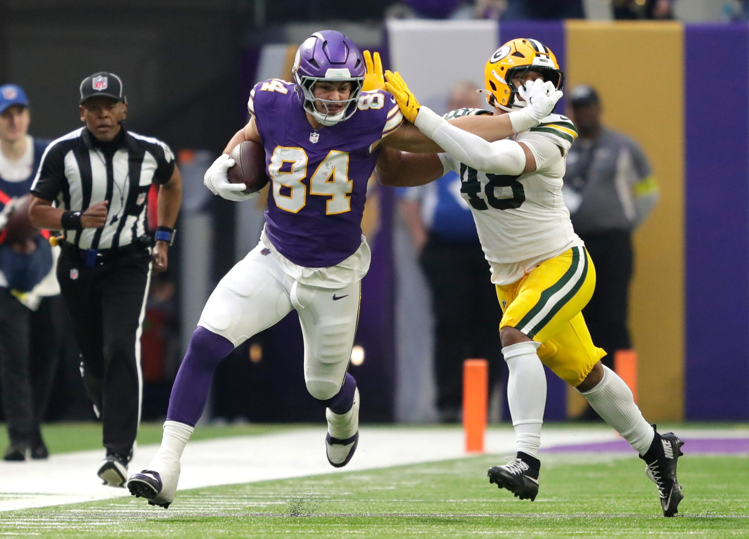 Minnesota Vikings tight end Josh Oliver (84) stiff arms Green Bay Packers linebacker Jamon Johnson (48) on a first down reception during their football game Sunday, January 4, 2026, at U.S. Bank Stadium in Minneapolis, Minnesota.