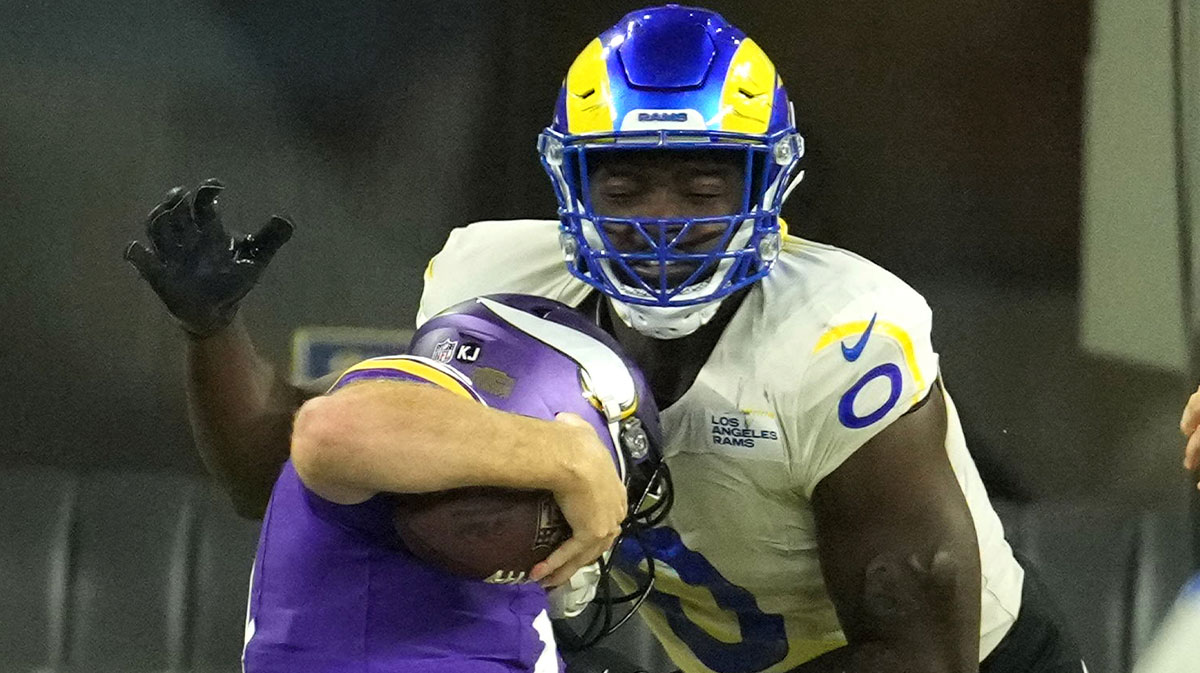 Los Angeles Rams linebacker Byron Young (0) tackles Minnesota Vikings quarterback Sam Darnold (14) for a safety in the second half at SoFi Stadium.