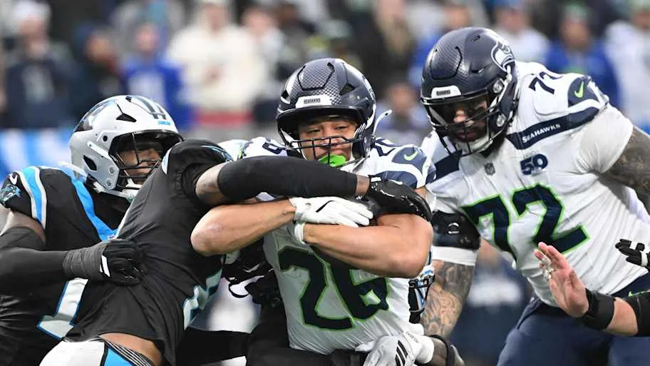 Seattle Seahawks running back Zach Charbonnet runs as Carolina Panthers linebacker D.J. Wonnum defends