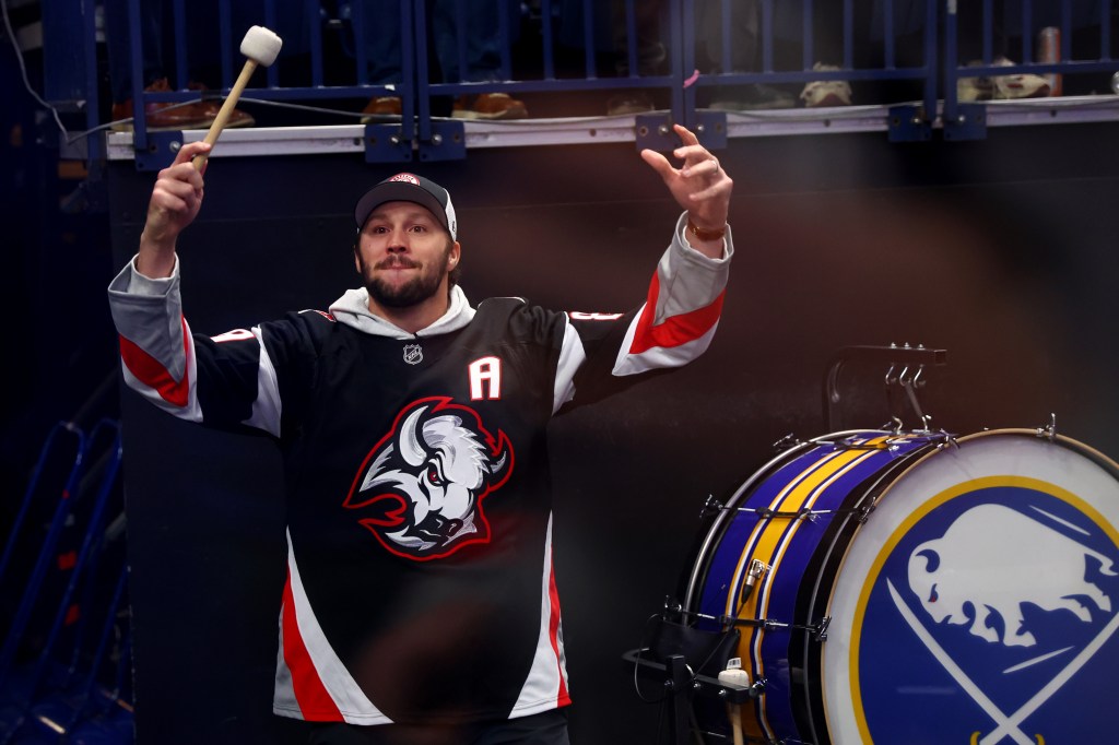 Buffalo Bills quarterback Josh Allen hyping up the crowd at a Buffalo Sabres game.