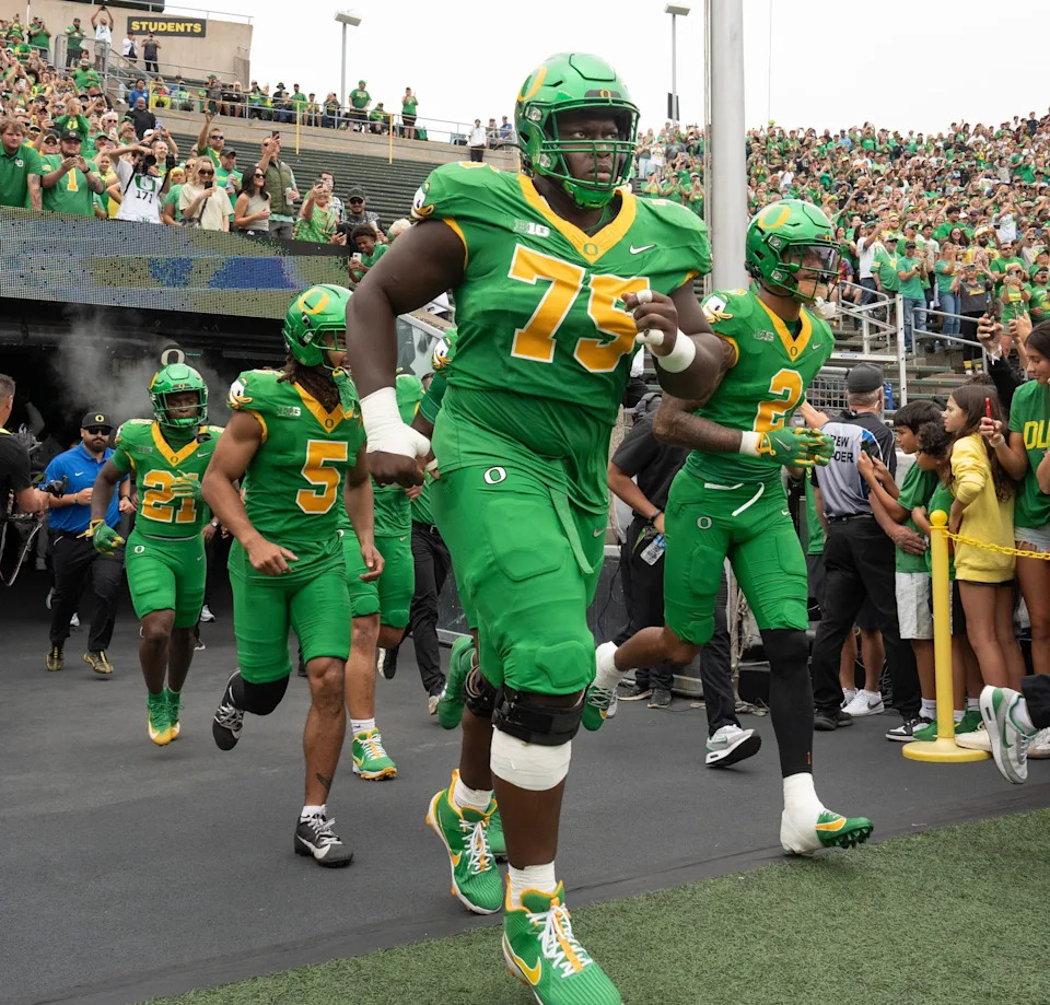 Oregonâ€™s Emmanuel Pregnon, center, takes the field before the game against Oklahoma State at Autzen.