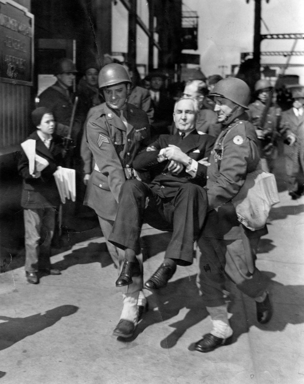 Soldiers carry Sewell Avery, chairman of the board of Montgomery Ward & Co., out of the building on April 27, 1944, after he was removed from his own office by the army on instructions of Atty. Gen. Biddle. Avery had defied the department of commerce when it tried to take over the huge plant. (Frederick Giese/Chicago Tribune) 