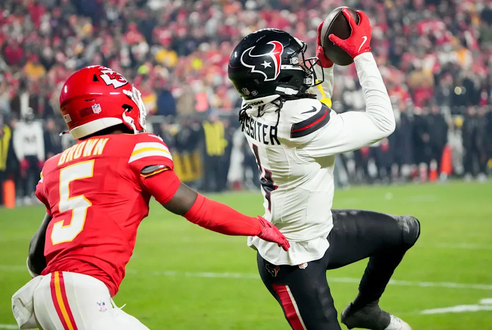 Dec 7, 2025; Kansas City, Missouri, USA; Houston Texans cornerback Kamari Lassiter (4) intercepts a pass intended for Kansas City Chiefs wide receiver Hollywood Brown (5) during the fourth quarter at GEHA Field at Arrowhead Stadium. Mandatory Credit: Denny Medley-Imagn Images