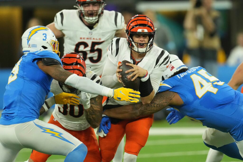 Cincinnati Bengals quarterback Joe Burrow (9) is pressured by Los Angeles Chargers safety Derwin James Jr. (3) and linebacker Tuli Tuipulotu (45) in the first half at SoFi Stadium.