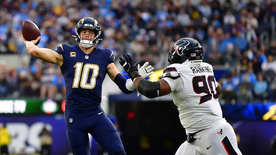 Justin Herbert throws the ball as Houston Texans defensive tackle Sheldon Rankins applies the pressure.
