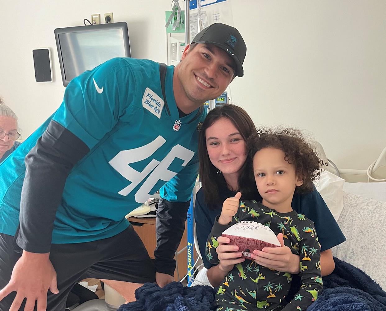 Jacksonville Jaguars long snapper Ross Matiscik visits Bella (center) with her little brother during a visit with patients at the Wolfson Children's Hospital.