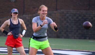 A flag football coach watches a quarterback prepare to catch the ball.