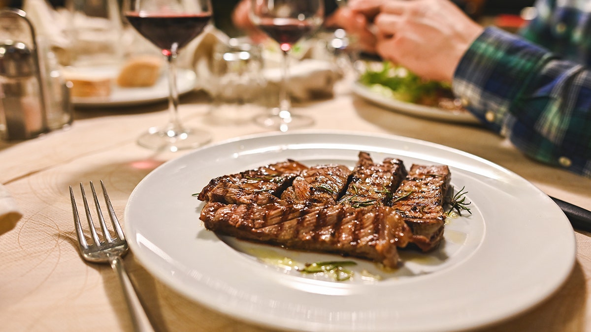 Steak on plate near wine