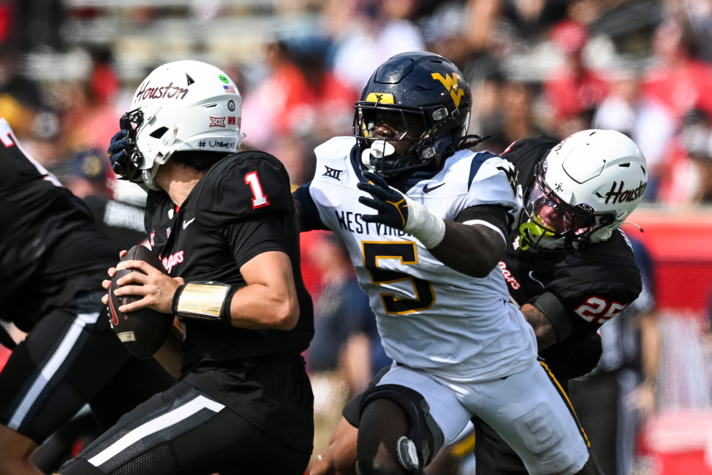 HOUSTON, TEXAS - NOVEMBER 01: Fred Perry #5 of the West Virginia Mountaineers pressures Conner Weigman #1 of the Houston Cougars during the fourth quarter at TDECU Stadium on November 01, 2025 in Houston, Texas. (Photo by Maria Lysaker/Getty Images)