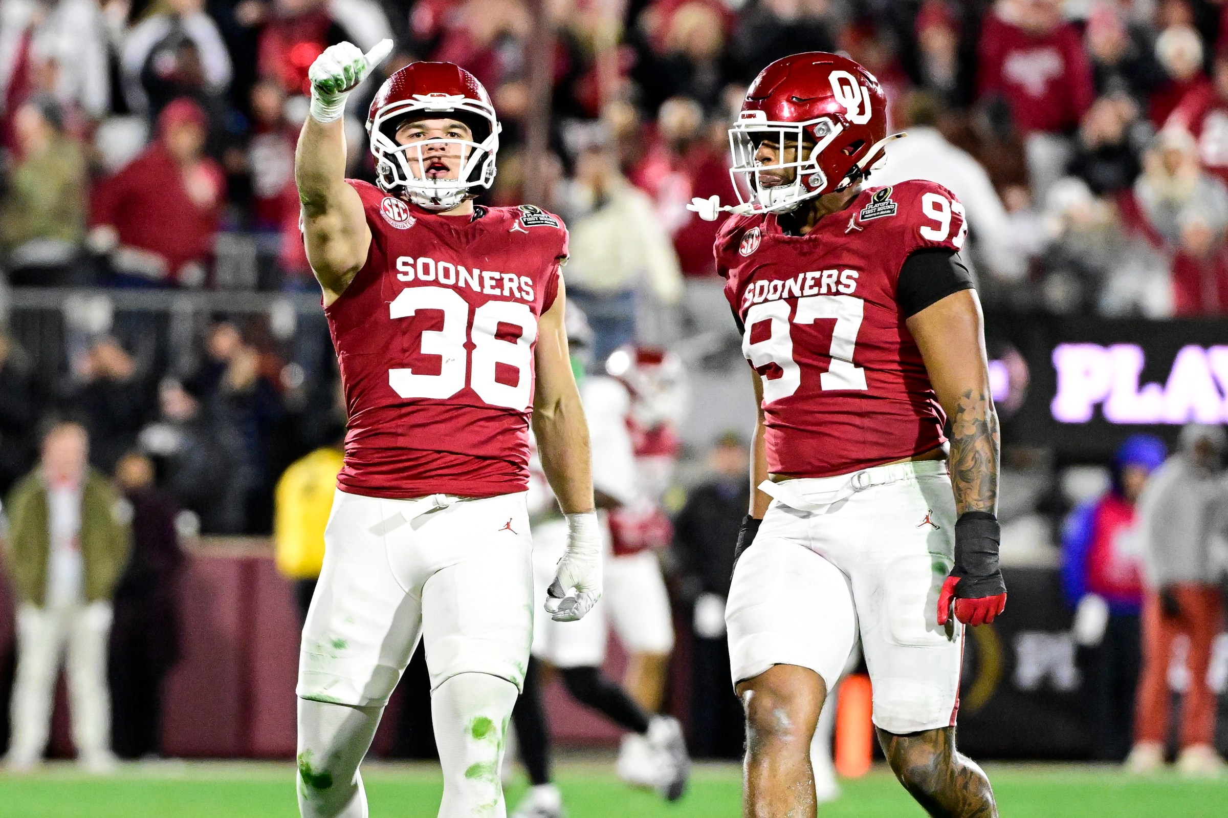 NORMAN, OKLAHOMA - DECEMBER 19: Owen Heinecke #38 and Marvin Jones Jr. #97 of the Oklahoma Sooners react in the second half during a 2025 College Football Playoff First Round Game against the Alabama Crimson Tide at Gaylord Family Oklahoma Memorial Stadium on December 19, 2025 in Norman, Oklahoma. (Photo by CFP/Getty Images)