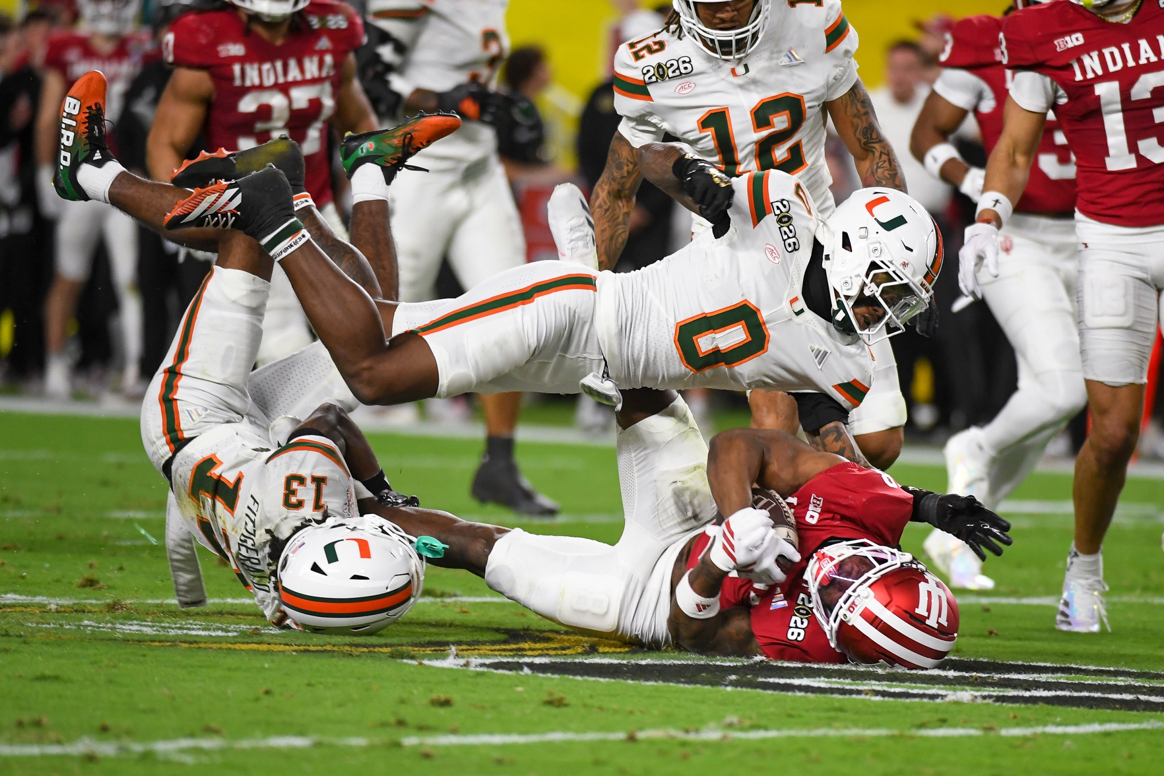 MIAMI GARDENS, FLORIDA - JANUARY 19: Kaelon Black #8 of the Indiana Hoosiers is tackled by Keionte Scott #0 of the Miami Hurricanes and Bryce Fitzgerald #13 during the first half of the College Football Playoff National Championship between the Indiana Hoosiers and the Miami Hurricanes at Hard Rock Stadium on January 19, 2026 in Miami Gardens, Florida. (Photo by CFP/Getty Images)