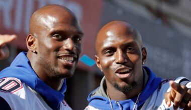 In this Feb. 5, 2019, file photo, New England Patriots Jason, left, and Devin McCourty react to fans during their Super Bowl victory parade in Boston. The Patriots’ twin combination in the secondary will remain intact for another season. A person familiar with the move says cornerback Jason McCourty has agreed to a two-year deal to remain with the Super Bowl champions. The person spoke on the condition of anonymity to The Associated Press because teams are not permitted to announce any moves until later in the day.