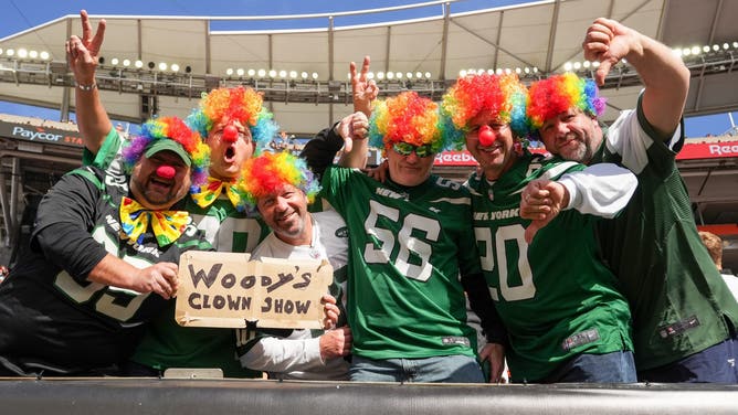 New York Jets fans pose for a photo while wearing clown wigs prior to a game at Paycor Stadium against the Cincinnati Bengals.