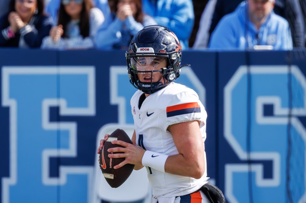 Chandler Morris wearing a white Virginia football jersey and black helmet, holding a football.