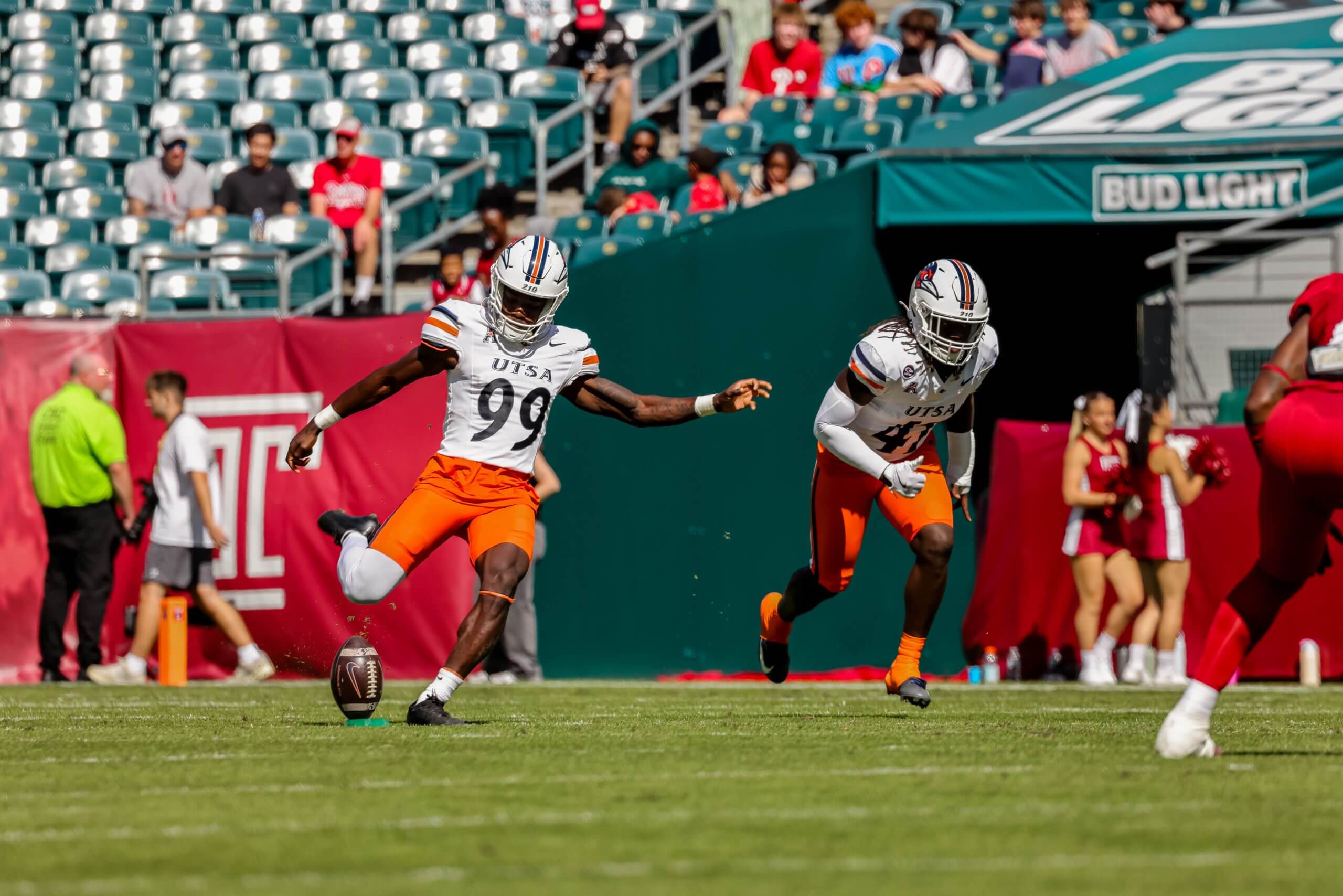 Jaffer Murphy, in a UTSA uniform, kicks the football off a tee in the stadium.