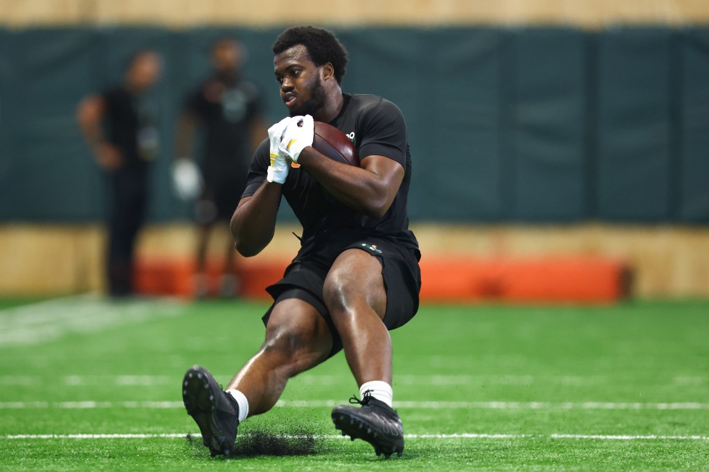 Rueben Bain Jr. in a black shirt, shorts, and cleats catches a football at the 2026 Miami Pro Day.