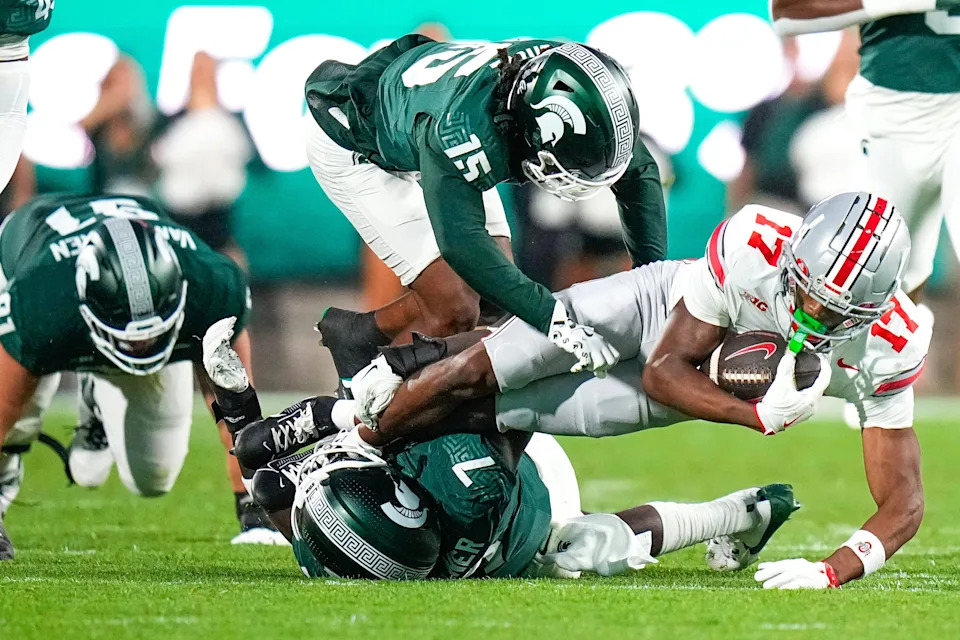 Sep 28, 2024; East Lansing, Michigan, USA; Ohio State Buckeyes wide receiver Carnell Tate (17) is tackled by Michigan State Spartans in the first half at Spartan Stadium on Saturday.