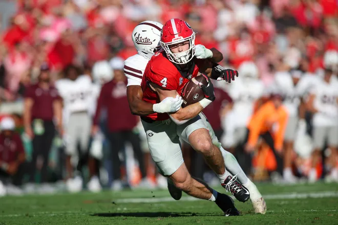 Oct 12, 2024; Athens, Georgia, USA; Georgia Bulldogs tight end Oscar Delp (4) is tackled by Mississippi State Bulldogs safety Isaac Smith (2) in the second quarter at Sanford Stadium. Mandatory Credit: Brett Davis-Imagn Images