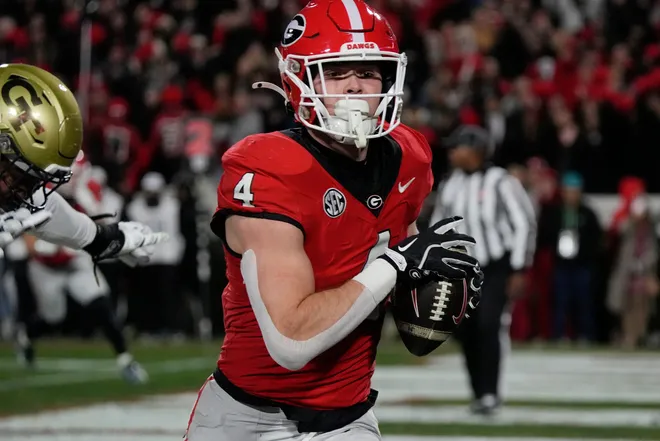 Georgia tight end Oscar Delp (4) scores a touchdown during the second half of a NCAA college football game against Georgia Tech in Athens, Ga., on Friday, Nov. 29, 2024.