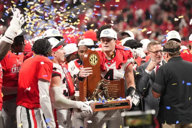 Dec 6, 2025; Atlanta, GA, USA; Georgia Bulldogs tight end Oscar Delp (4) holds the SEC Championship trophy after the game against the Alabama Crimson Tide during the 2025 SEC Championship game at Mercedes-Benz Stadium. Mandatory Credit: Dale Zanine-Imagn Images