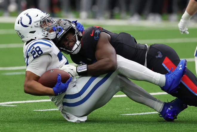 Indianapolis Colts running back Jonathan Taylor (28) is tackled by. Houston Texans defensive end Will Anderson Jr. (51).