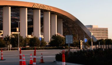 Image of SoFi Stadium and its exterior columns along with an adjacent street and orange traffic cones