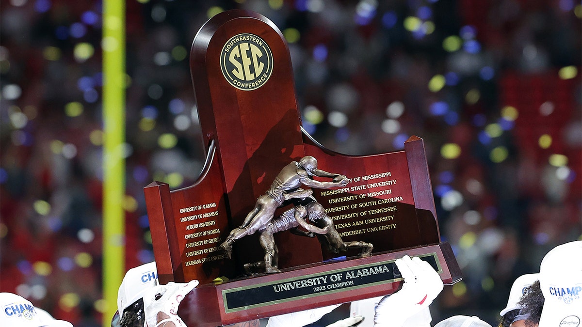 Alabama Crimson Tide players celebrating with SEC Championship trophy at Mercedes-Benz Stadium