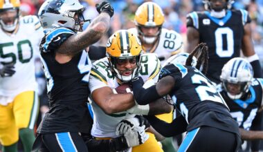 Dec 24, 2023; Charlotte, North Carolina, USA; Green Bay Packers running back AJ Dillon (28) with the ball as Carolina Panthers linebacker Frankie Luvu (49) and cornerback Donte Jackson (26) defend in the third quarter at Bank of America Stadium.